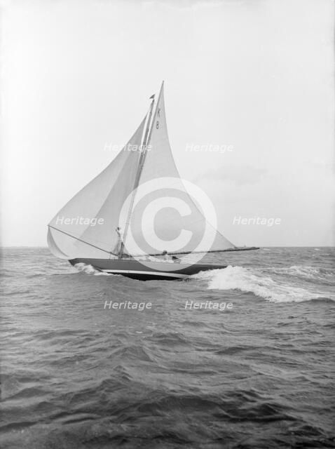 The 7 Metre yacht 'Pinaster' (K8) sailing with spinnaker, 1913. Creator: Kirk & Sons of Cowes.