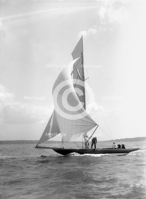 The 8 Metre 'Termagant' sailing with spinnaker, 1911. Creator: Kirk & Sons of Cowes.