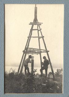 The moment of carrying out triangulation measurements under a tower on the river bank, 1909. Creator: Vladimir Ivanovich Fedorov