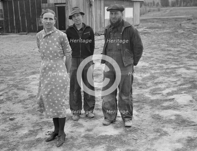 The mother, father, and hardworking fifteen-year-old son in yard..., Boundary County, Idaho, 1939. Creator: Dorothea Lange.