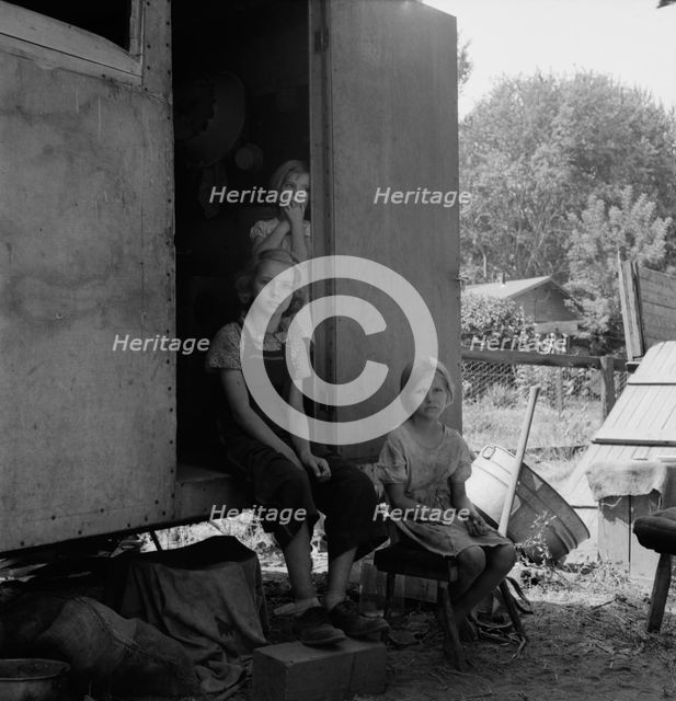 The oldest girl seated in the doorway of the house trailer..., Yakima Valley, Washington, 1939. Creator: Dorothea Lange.