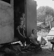 The oldest girl seated in the doorway of the house trailer..., Yakima Valley, Washington, 1939. Creator: Dorothea Lange