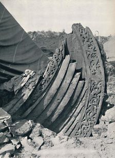 The Oseberg ship in the mound, showing the carving on stem and railing 1935