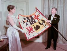 The Australian High Commissioner to Britain and his wife holding the standard of Australia, 1953. Creator: Arthur Charles Kirby Ware