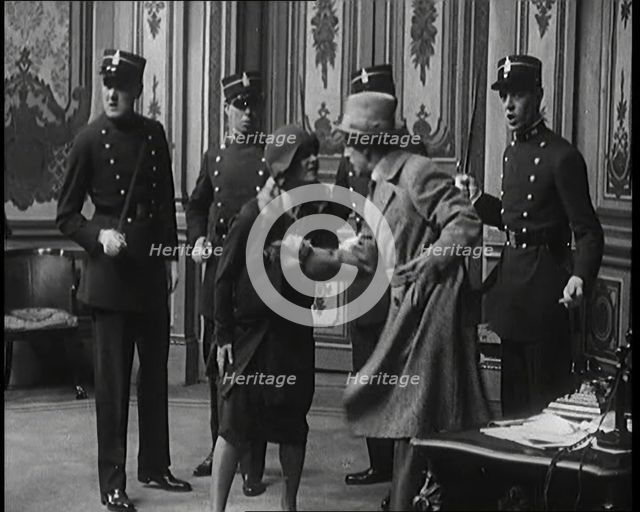 The Actor Gene Gerrard Hand Cuffed to His Co Star Being Watched By French Police They..., 1920s. Creator: British Pathe Ltd.