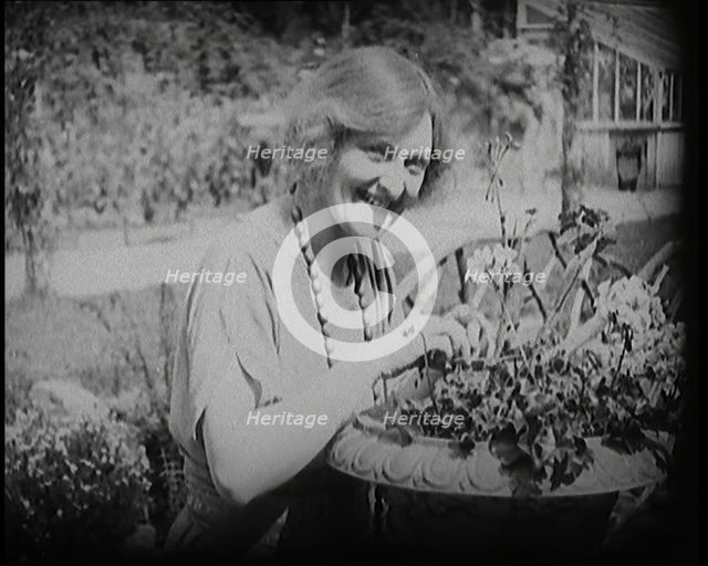 The Actress Sybil Thorndike Tending Her Flowers in a Garden, 1920s. Creator: British Pathe Ltd.