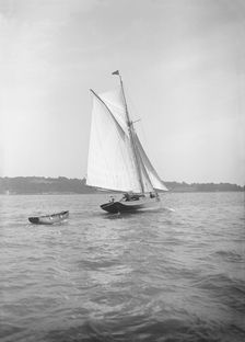 The cutter Citara under sail and towing tender, 1911. Creator: Kirk & Sons of Cowes
