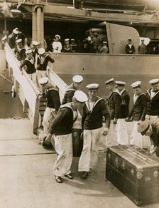 The crew of H.M.S. Hood unload cases at Portsmouth, July 1935. Creator: Topical Press Agency