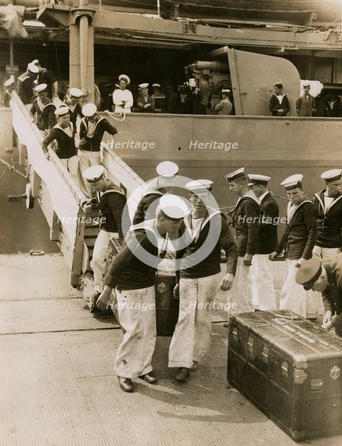 The crew of H.M.S. Hood unload cases at Portsmouth, July 1935.  Creator: Topical Press Agency.