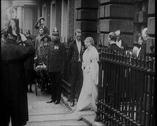 The Duke of York and Lady Elizabeth Bowes-Lyon Emerging from a House on Their Wedding Day, 1920. Creator: British Pathe Ltd