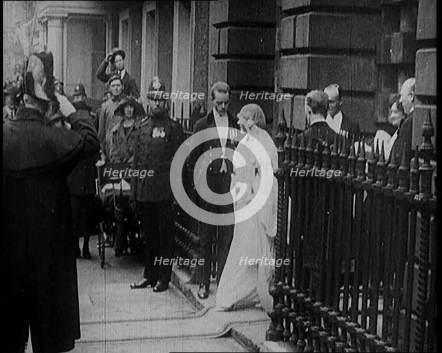 The Duke of York and Lady Elizabeth Bowes-Lyon Emerging from a House on Their Wedding Day, 1920. Creator: British Pathe Ltd.