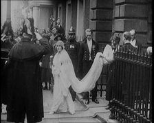 The Duke of York and Lady Elizabeth Bowes-Lyon Emerging from a House on Their Wedding Day, 1920. Creator: British Pathe Ltd