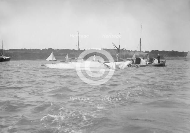 The dismasted sailing yacht 'Clio' is attended to by rescue boats, 1912. Creator: Kirk & Sons of Cowes.