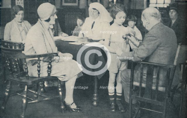 'The Doctor listening to a child's heart beat', c1935. Artist: Unknown.