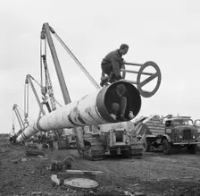The Fens gas pipeline being lifted by a row of Caterpillar 583 pipelayers, Norfolk, 20/09/1967. Creator: John Laing plc