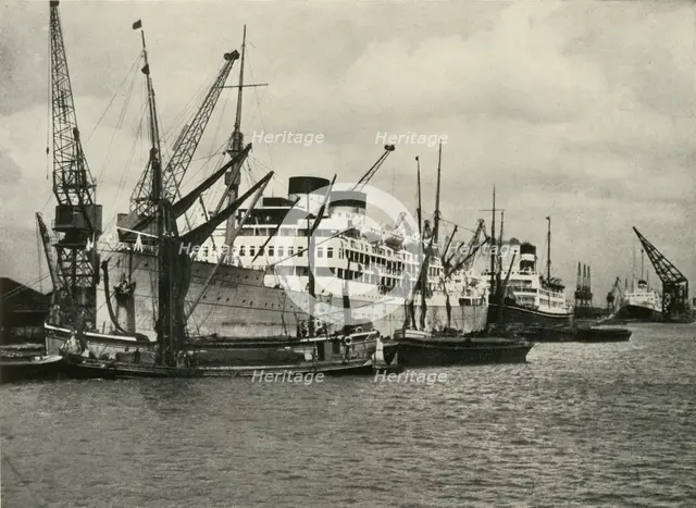 "The Forest of Masts Has Given Place to a Cluster of Steamer Funnels" Vessels Berthed at...', 1937. Creator: Unknown.