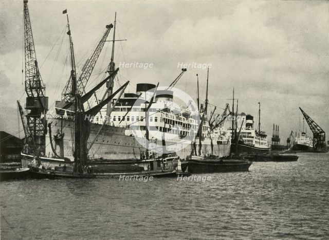 "The Forest of Masts Has Given Place to a Cluster of Steamer Funnels" Vessels Berthed at...', 1937. Creator: Unknown.