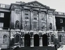 The front entrance of Guy's Hospital, with statues of Aesculapius and Hygieia above the arches. Creator: Unknown