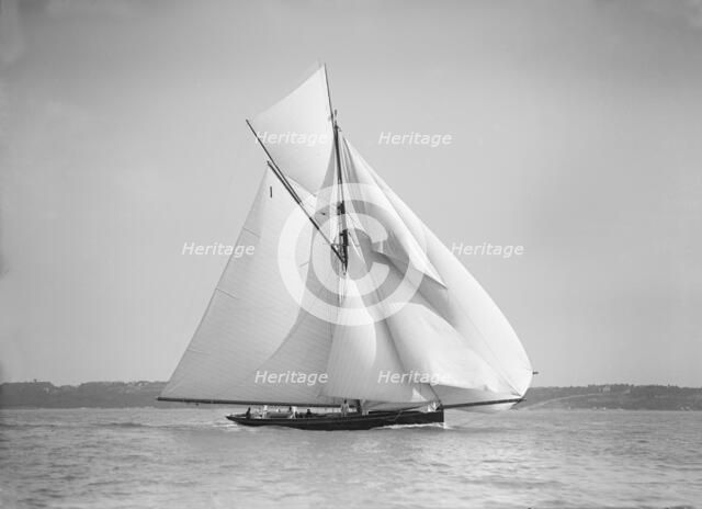 The gaff rigged cutter 'Bloodhound' sailing downwind with spinnaker, 1911. Creator: Kirk & Sons of Cowes.