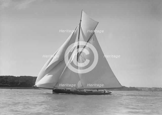 The gaff rigged cutter 'Bloodhound' sailing downwind under spinnaker, 1911. Creator: Kirk & Sons of Cowes.