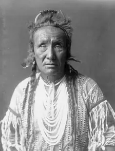 The Grizzly Bear, Piegan, half-length portrait, facing front, c1910. Creator: Edward Sheriff Curtis