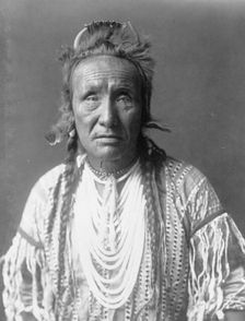 The Grizzly Bear, Piegan, half-length portrait, facing front, c1910. Creator: Edward Sheriff Curtis