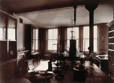 The interior of a pharmaceutical or chemical laboratory, with two long benches in the centre, glass. Creator: Unknown