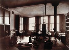 The interior of a pharmaceutical or chemical laboratory, with two long benches in the centre, glass. Creator: Unknown