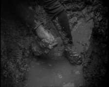 The Legs and Boots of a Male French Soldiers as He is Standing in a Water-Logged Muddy Trench, 1939. Creator: British Pathe Ltd