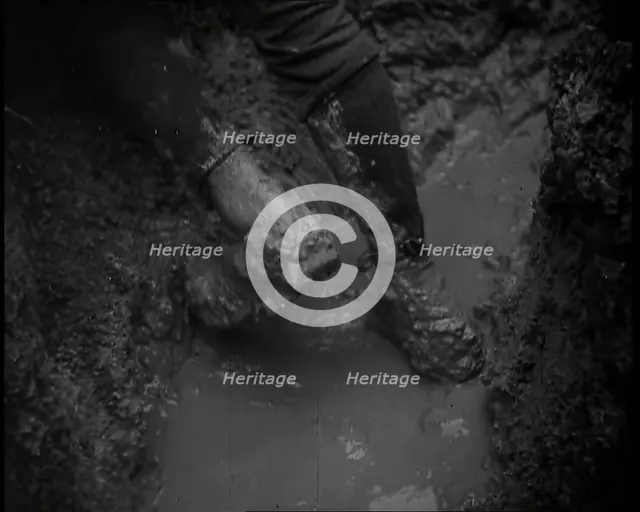 The Legs and Boots of a Male French Soldiers as He is Standing in a Water-Logged Muddy Trench, 1939. Creator: British Pathe Ltd.