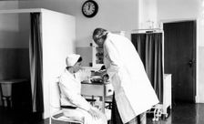 The Rowntree doctor examines the arm of a member of staff, Rowntree Factory, York, Yorkshire, 1953