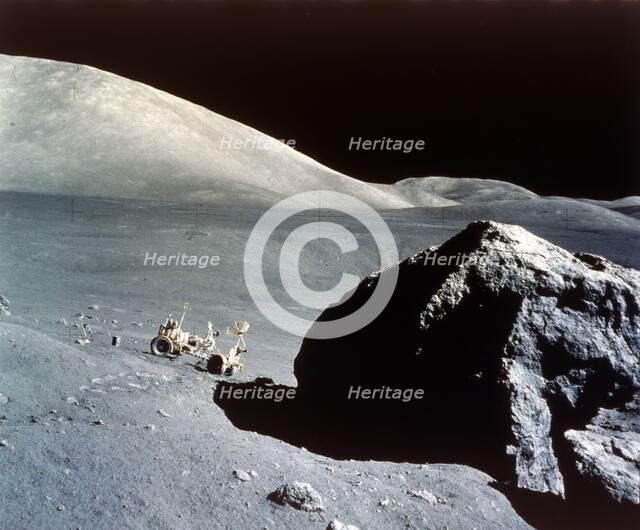 The Rover is dwarfed by a giant rock on the lunar surface, Apollo 17 mission, December 1972. Creator: NASA.