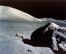The Rover is dwarfed by a giant rock on the lunar surface, Apollo 17 mission, December 1972. Creator: NASA