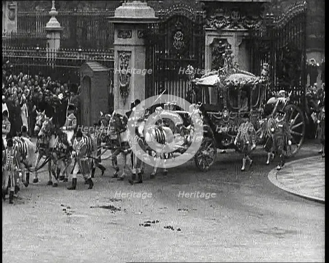The Royal Coach, Horses, and Procession Filing Out of the Gates at the Front of Buckingham..., 1937. Creator: British Pathe Ltd.