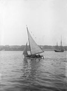 The sailing dinghy Hound with flags, 1912. Creator: Kirk & Sons of Cowes