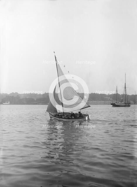The sailing dinghy 'Hound' with flags, 1912. Creator: Kirk & Sons of Cowes.