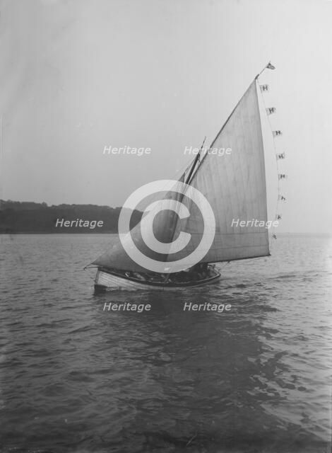 The sailing dinghy 'Hound' with flags, 1912. Creator: Kirk & Sons of Cowes.