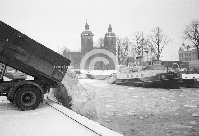 The snow clearance squad tip snow into the harbour, Landskrona, Sweden 1958. Creator: Unknown.