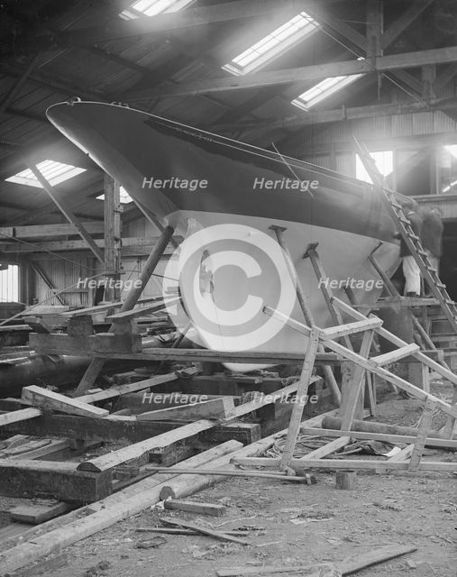 The yawl 'Banzai' in shed at boatyard, 1912. Creator: Kirk & Sons of Cowes.