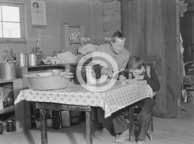 The youngest Wardlow boy copies out a recipe for his mother, Dead Ox Flat, Oregon, 1939. Creator: Dorothea Lange.