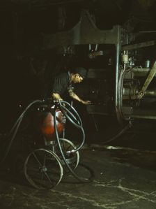 Thomas Madrigal greasing a locomotive in the roundhouse, Rock Island R.R., Blue Island, Ill., 1943. Creator: Jack Delano