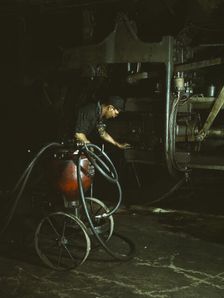Thomas Madrigal greasing a locomotive in the roundhouse, Rock Island R.R., Blue Island, Ill., 1943. Creator: Jack Delano