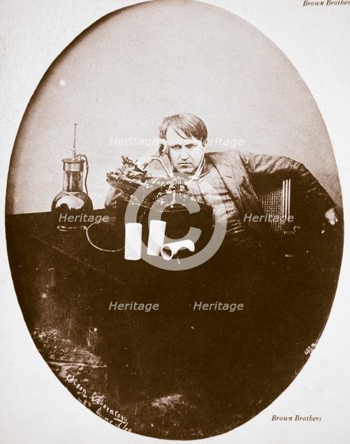 Thomas Alva Edison, American inventor, sitting beside his improved machine, 1889. Artist: Unknown