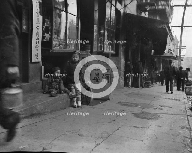 Three children in front of a cellar door, Chinatown, San Francisco, between 1896 and 1906. Creator: Arnold Genthe.