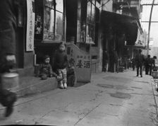 Three children in front of a cellar door, Chinatown, San Francisco, between 1896 and 1906. Creator: Arnold Genthe