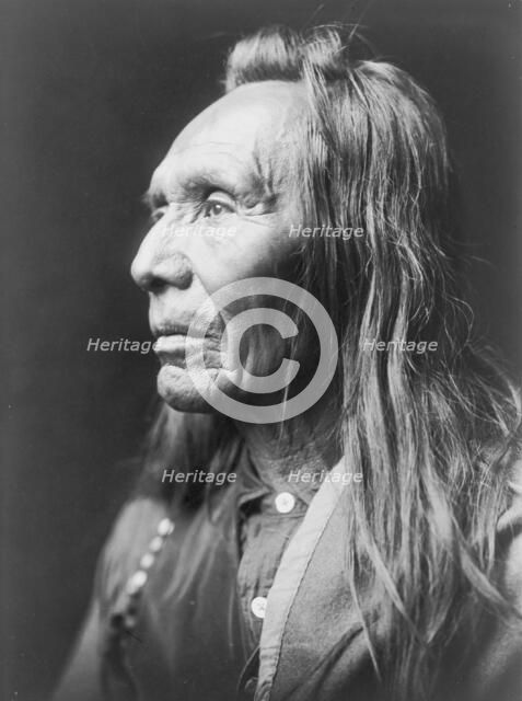 Three Eagles, a Nez Percé Indian, head-and-shoulders portrait, facing left, c1910. Creator: Edward Sheriff Curtis.