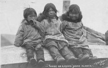 Three Eskimo children seated side by side, between c1900 and c1930. Creator: Lomen Brothers