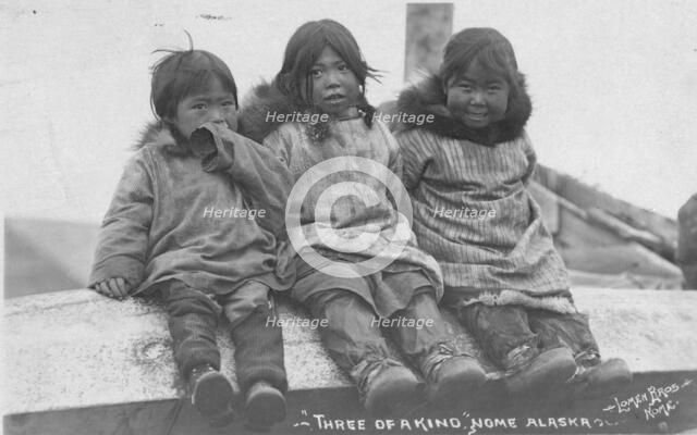 Three Eskimo children seated side by side, between c1900 and c1930. Creator: Lomen Brothers.