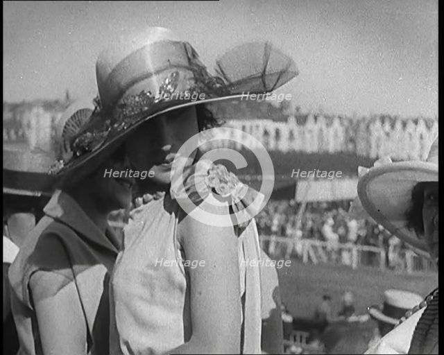 Three Female Civilians Wearing Smart Summer Outfits and Hats Chatting at the Horse Race, 1920. Creator: British Pathe Ltd.
