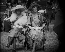 Three Female Civilians Seating Outdoors Wearing Evening Outfits and Hats, 1920. Creator: British Pathe Ltd